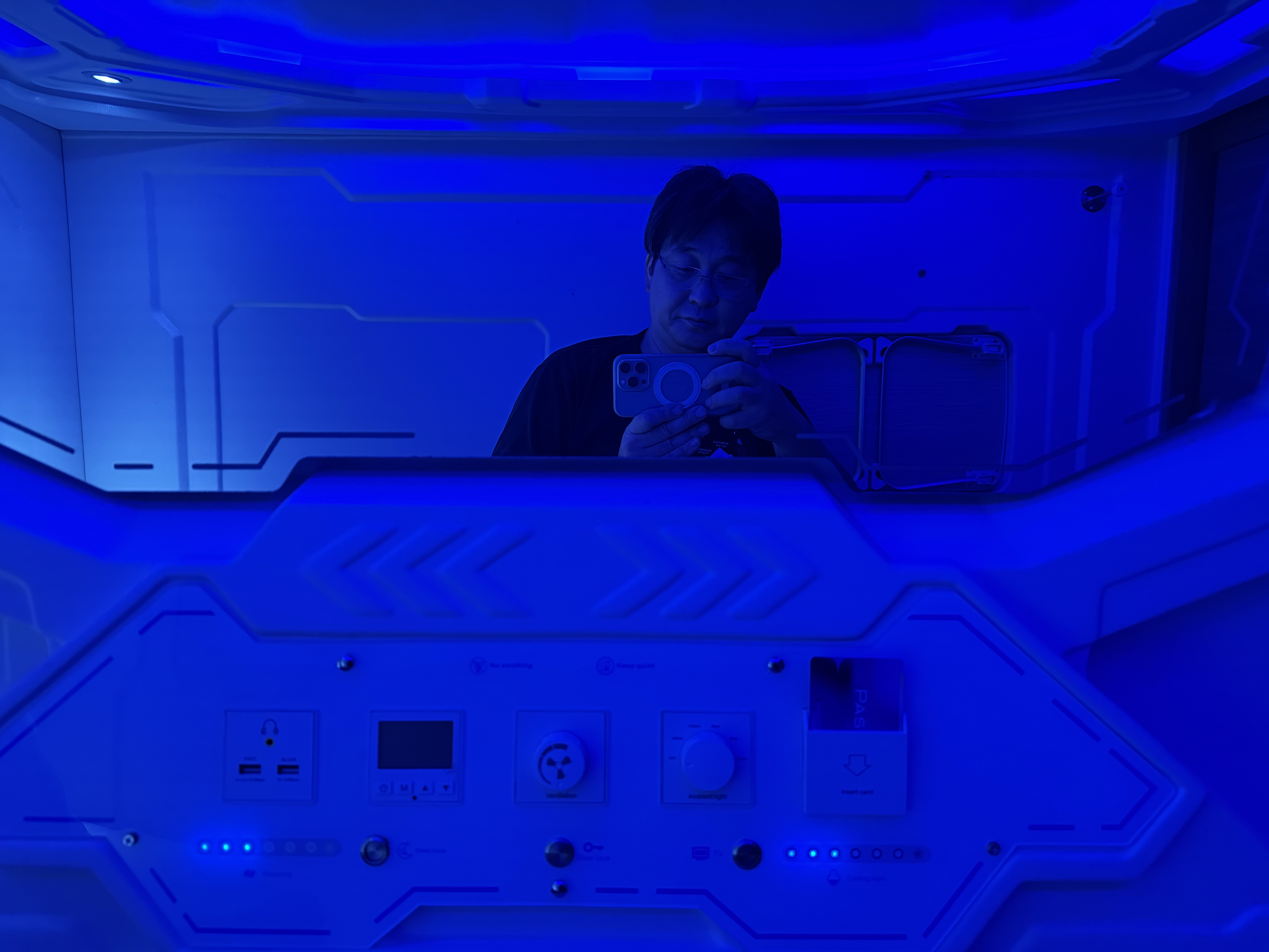 カプセルの中。青いアンビエントライトと、USBポート・時計・換気・ライトの操作パネル